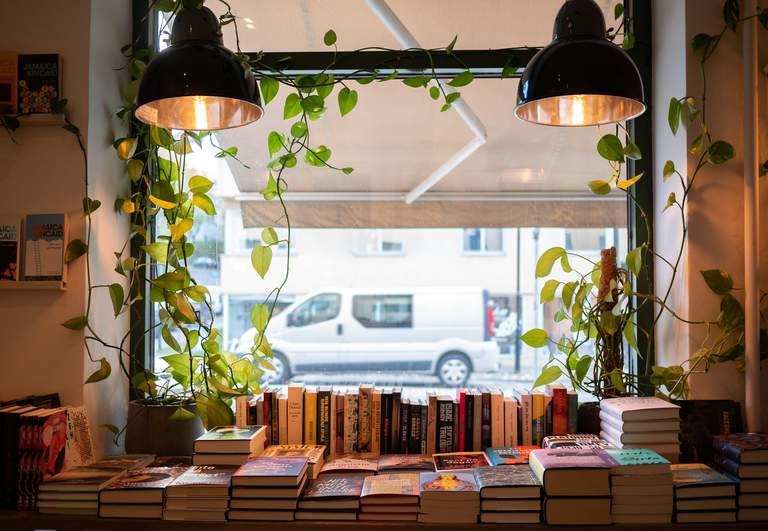 Shopping in Stockholm. Books are lined up by Aspuddens Bokhandel's storefront window.