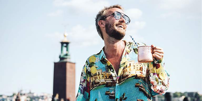 Fredrik Robertsson having a drink with Stockholm City Hall in the backgropund.