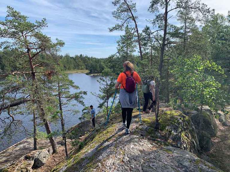 People walking on cliffs enjoying the view over the water.