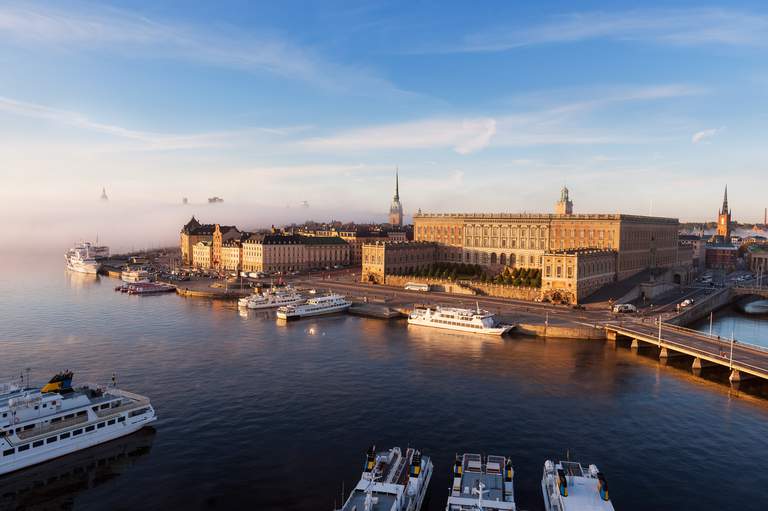 Gamla Stan, The Old town, in Stockholm. Fog rolls in over Gamla Stan during sunrise. Pictured is the Royal Palace, lit by the early morning light.