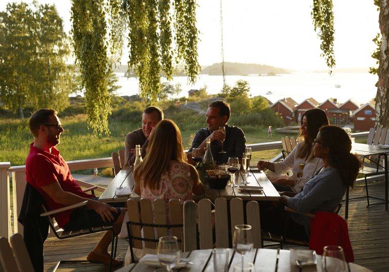 A group of friends sit outdoors at a restaurant on Grinda, an island in the Stockholm Archipelago.