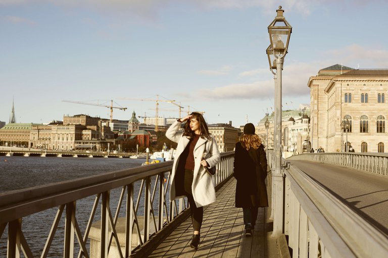 Two people walk past each other on Skeppsholmen Bridge in central Stockholm.