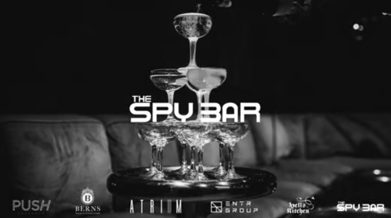 Champagne glasses and the name of the nightclub "The Spy Bar".