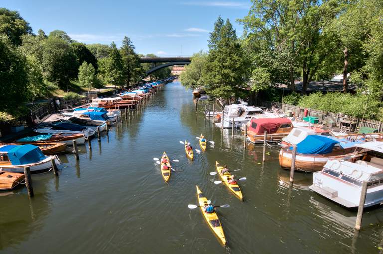 Several kayaks on a tour in a channel.