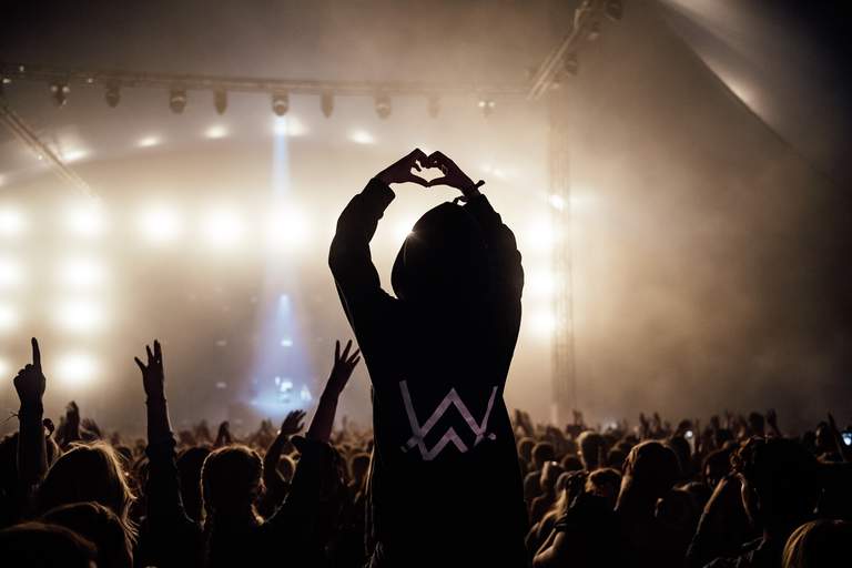Concerts and festivals in Stockholm. An audience member is sitting on another person's shoulders, making a heart shaped with her hands.