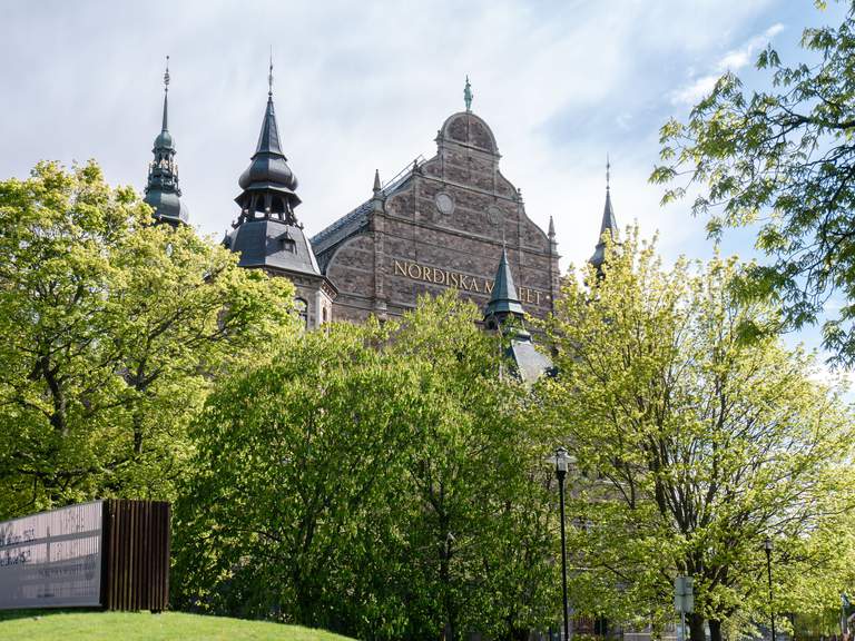 Museums in Stockholm. Nordiska museet on Djurgården, exterior. The picture is taken on a sunny spring day, with luch green treen in front of