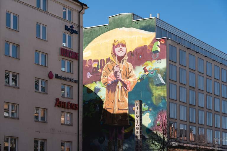 Street art in Stockholm. A large mural on Södermalm in Stockholm. The large graffiti painting shows a young girl in a yellow rain jacket holding an yellow umbrella.