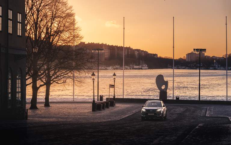 Travelling in Stockholm. A car drives along Riddarholmen during sunset.