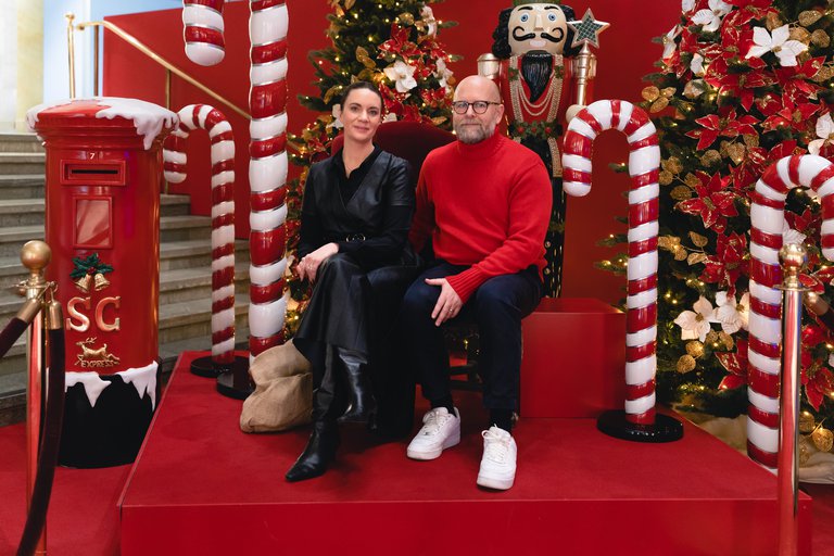 Sofie von Reis and Joakim Petterson. The Christmas decorations at NK. A man and a woman sit surronded by colorful christmas decorations.