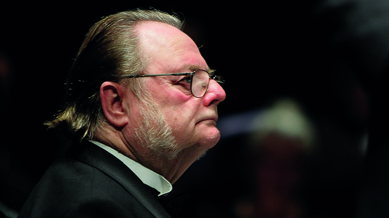 A portrait of a man in glasses.