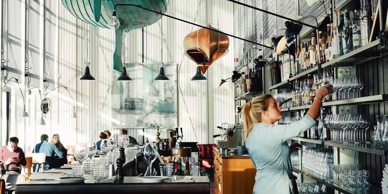 Lunchtime at Oaxen Krog & Slip in Stockholm. Oaxen is famous for both its menu and interior design. Remnants from its old history as a shipyard can be seen in the picture; old boats hanging from the high ceiling.