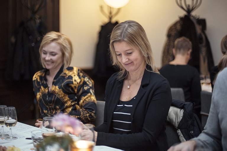 People sitting at at a table and tasting champagne.