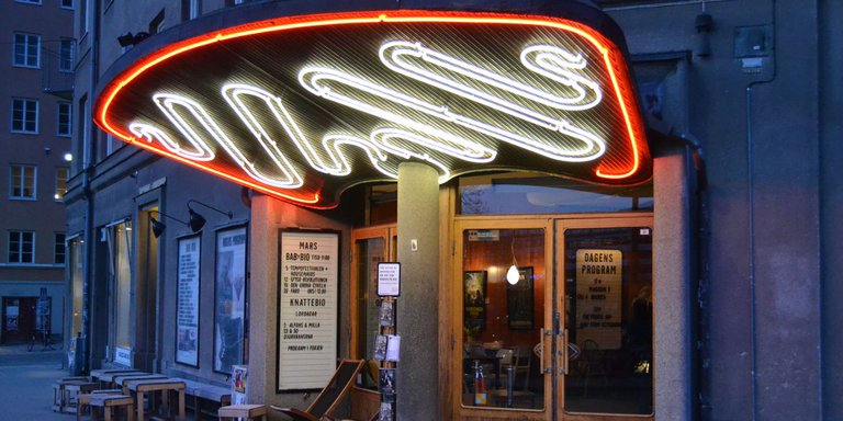 The picture is taken outside the cinema Bio Rio, Hornstull. By the entrance of Bio Rio there are a neon sign in white and red. Bio Rio was designed by the architect Albin Stark.