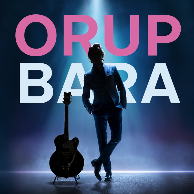 A musician with a guitar next to him and the text behind him "Orup bara".