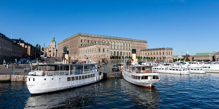 Strömma och Waxholmsbolagets båtar står anlagda vid kajen utanför Stockholms Slott. I Bakgrunden syns slottet, Storkyrka och Gamla Stan. Waxholmsbolaget och Strömma är två av Stockholms turoperatörer, med regelbundna turer ut i Skärgården och Mälaren.