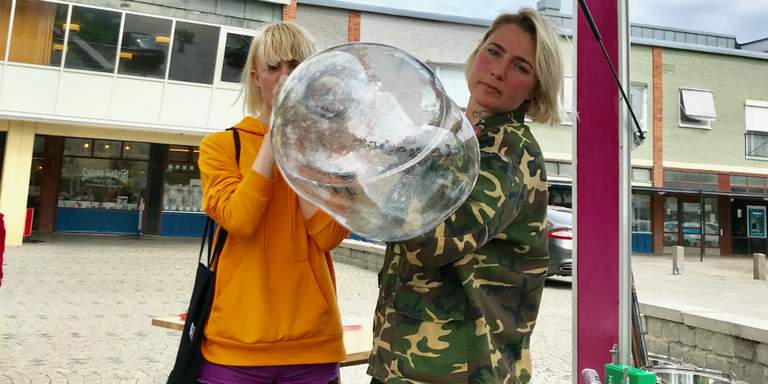 Arts and craft in Stockholm. A young woman tries out blowing glass for the first time with Spajsy, a mobile glassworks.
