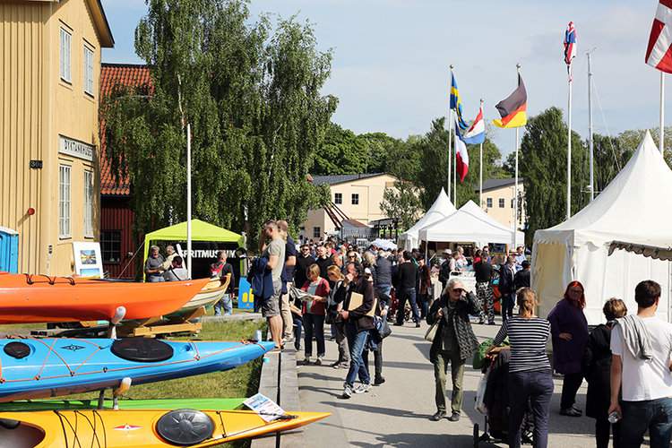 People walking among the fair stalls on a summer day.