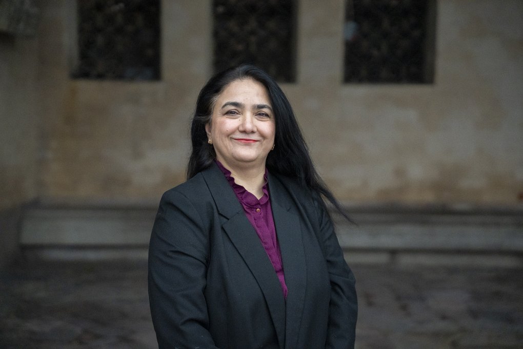 Dr Alia Amir outdoors in front of a stone building.