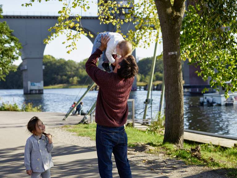 Two children playing with their parent outside in Stockholm