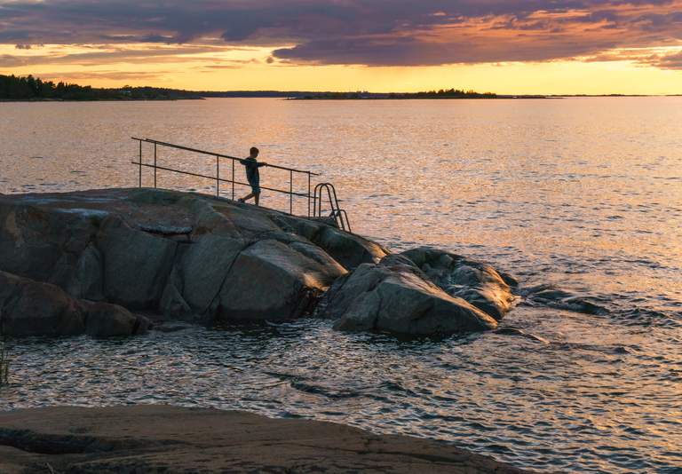 A child stands by the water in Öregrund in the Stockholm archipelago.