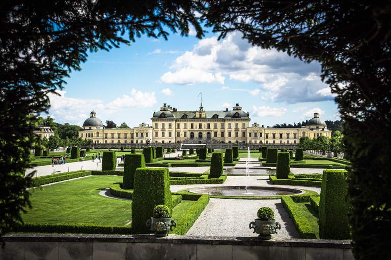 Slott i Stockholm. Drottningholms slott, exteriör. Slottet och dess park syns genom en växtportal.
