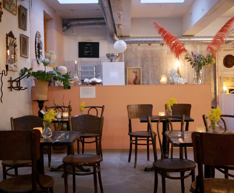 A café: tabels, chairs, flowers, pictures on the walls.