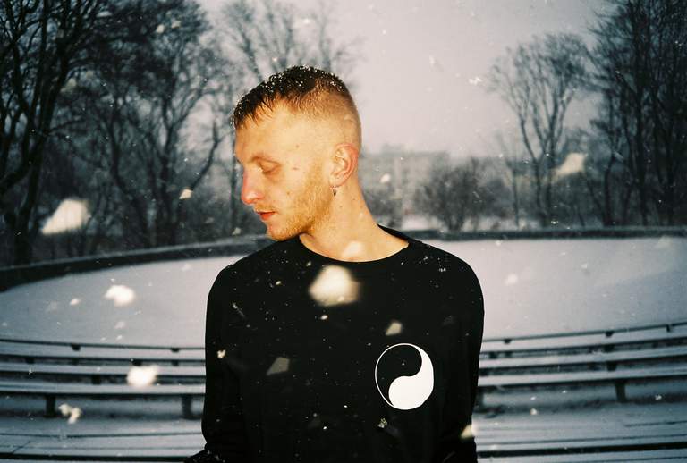 The artist Elias sitting outside on a snowy day.
