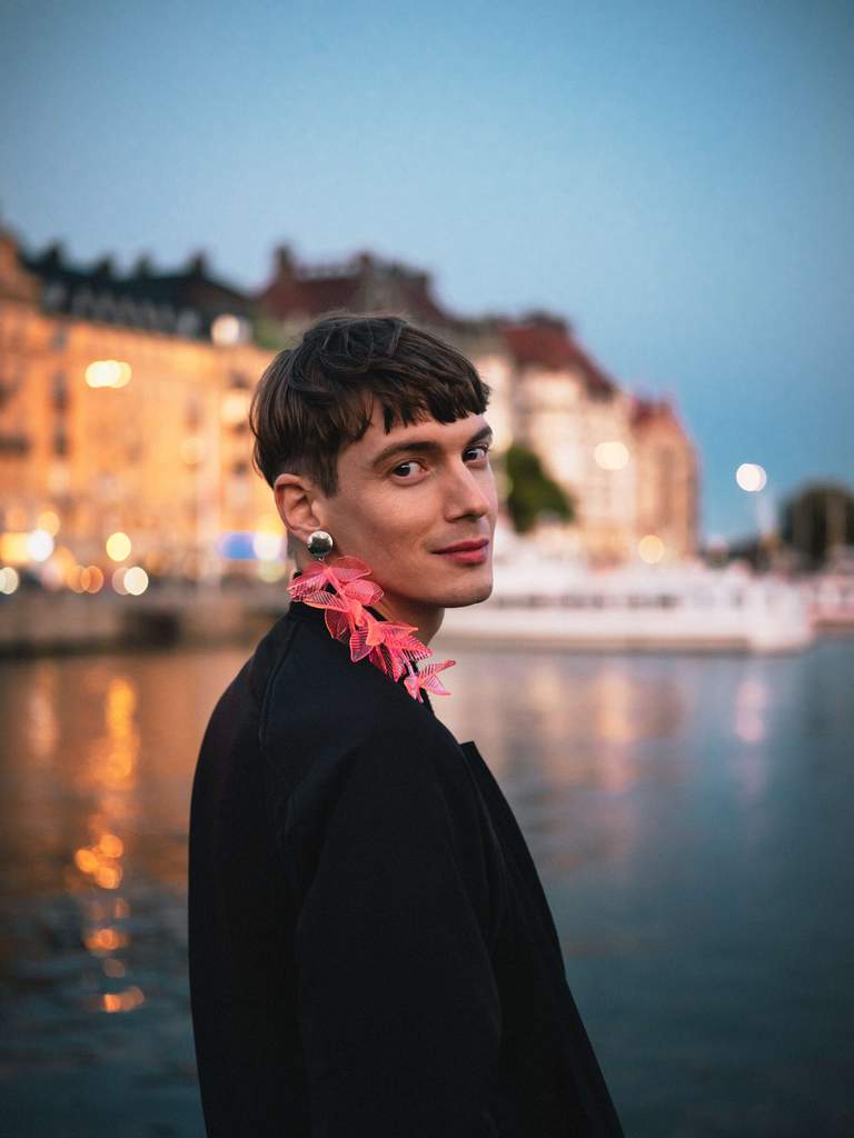 A man with an ear ring smiling at the camera