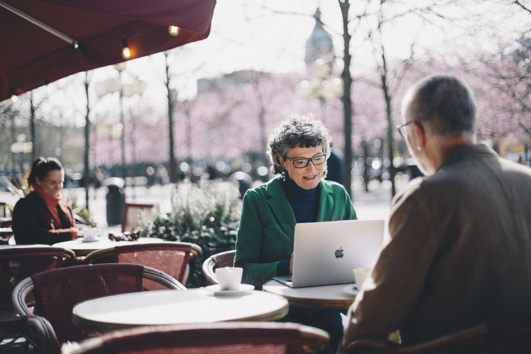 Two people meet for an outdoor business meeting at a café by Kungsträdgården in central Stockholm.