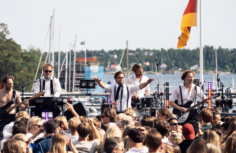 Musicians playing on a stage outdoors.