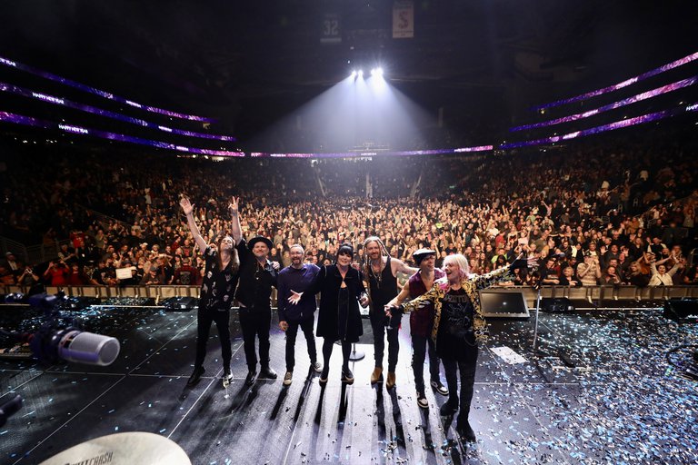 Musicians standing on a stage.