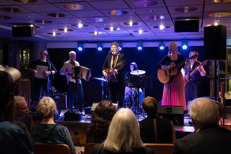 The musicians playing on a stage.