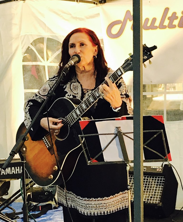 A musician playing a guitar and singing.