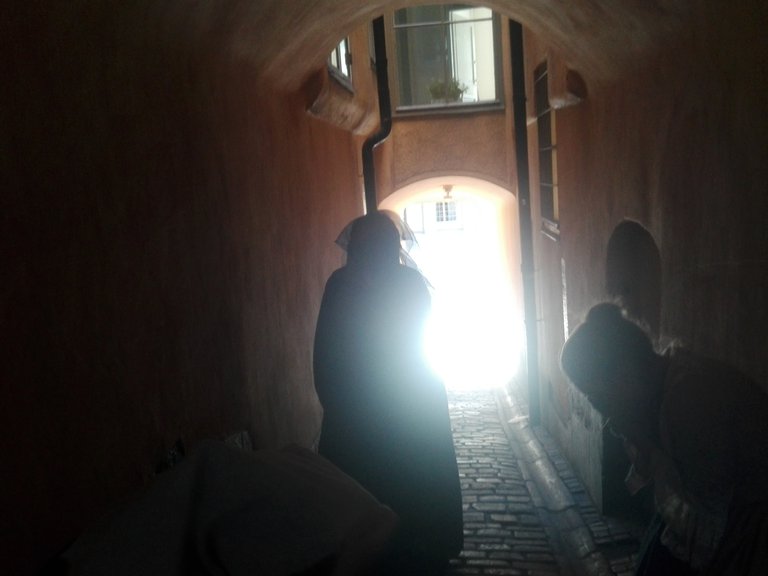 A silhouette of a person in a narrow street.