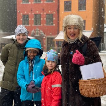 An adult and three children in the Old Town in snowy weather.