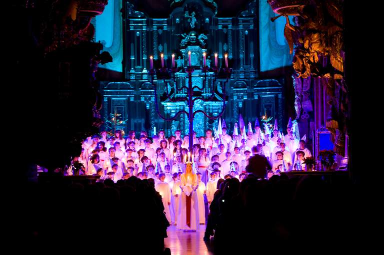 Lucia in Stockholm Cathedral. A choir is performing in front of an audience.