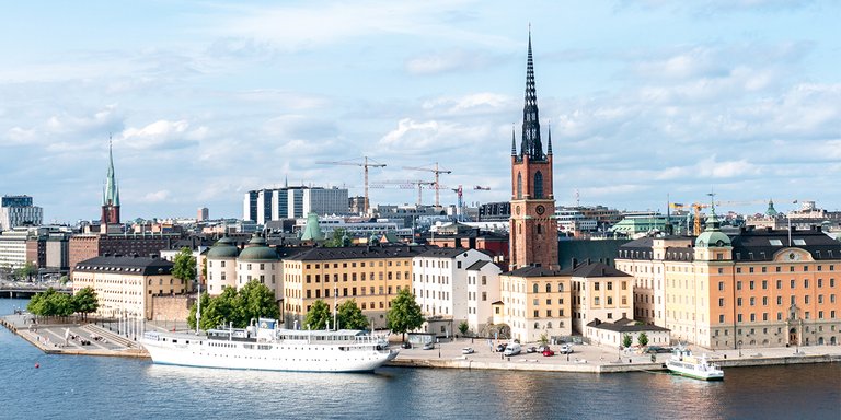 View over Gamla stan and the spire of Riddarholmen Church on a sunny day, with the blue sky above.