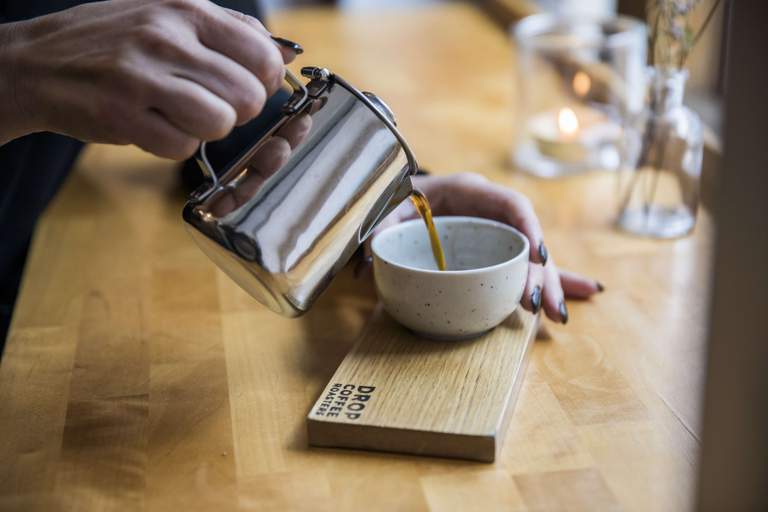 A hot cup of coffee being poured.