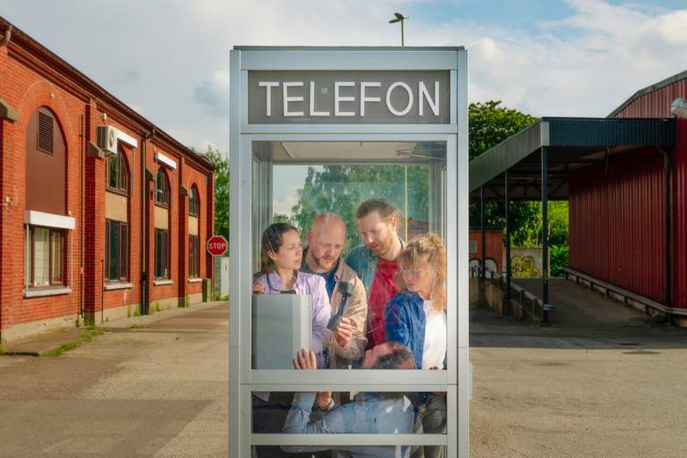 People in a a telephone booth.