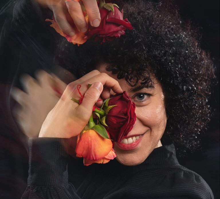 A smiling woman with roses in her hands.