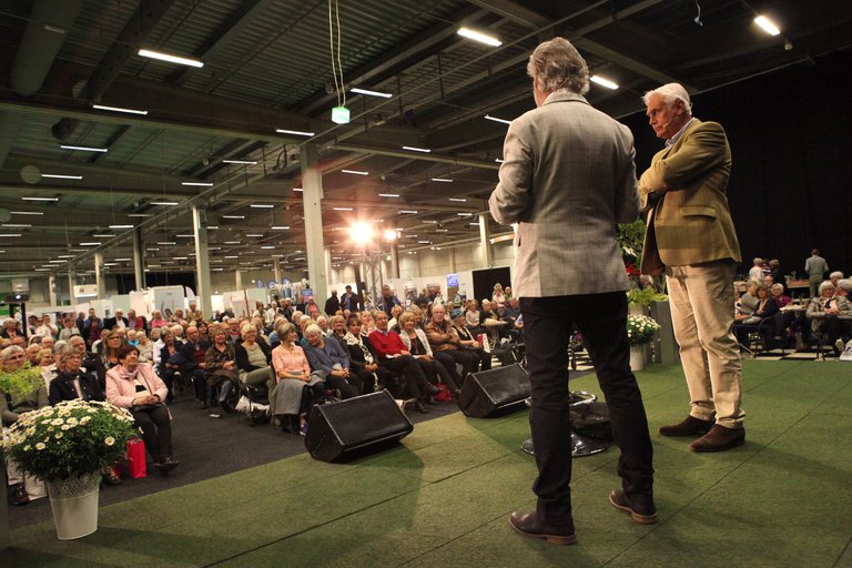 Two people on a stage in front of the audience.