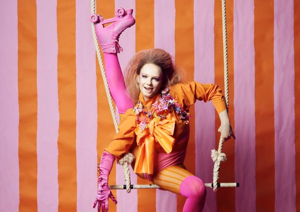 Circus artist haning in trapeze.