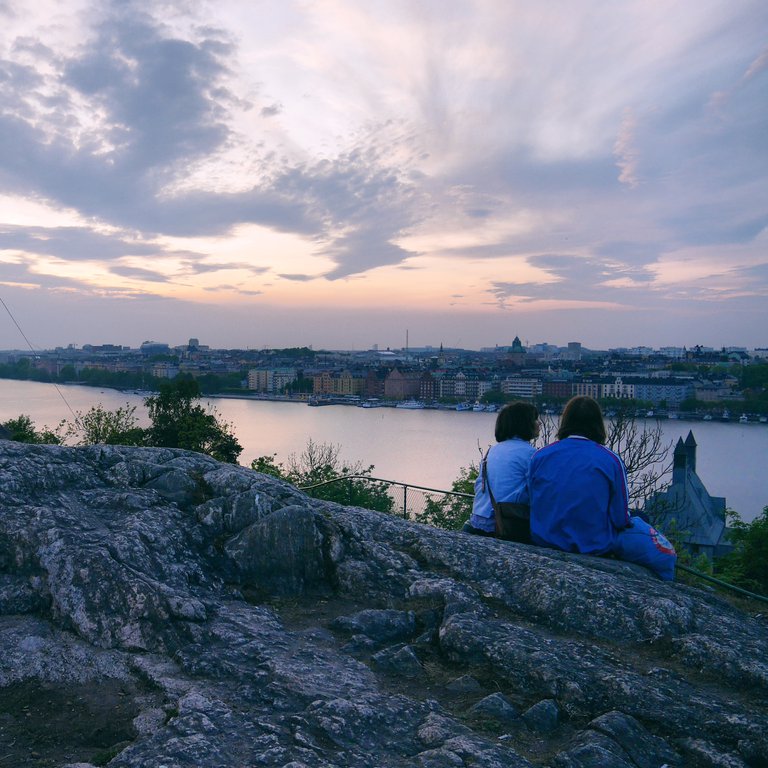 Afternoon in Stockholm. Two women sit and admire the view from Skinnarviksberget.