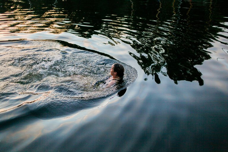 A young woman is swimming in the middle of Stockholm.