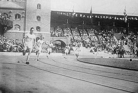 Athletes running at a stadium.