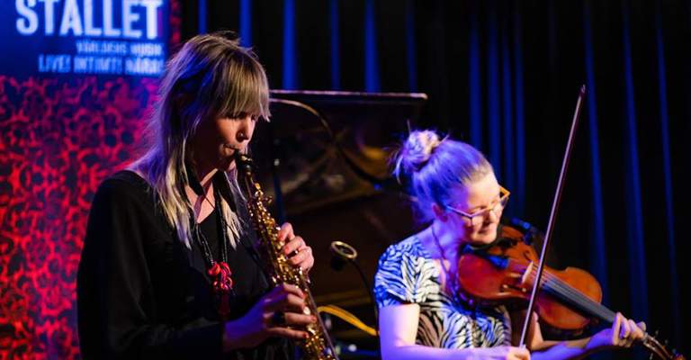 Two musicians playing clarinet and violin. In the background, we can see the name "Stallet".