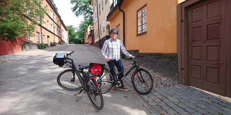 A person with two bikes on a city street.