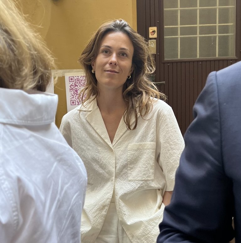 Therese Cappelen stands by a doorway as two people walk past her.