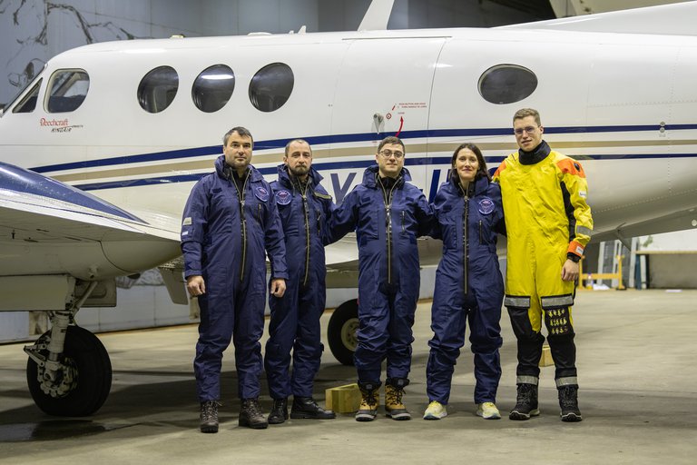 The research team standing at an airplane.