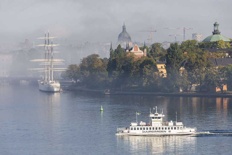 A boat travels from Djurgården to Slussen on a foggy summer day in Stockholm